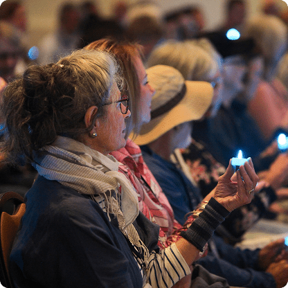 People gathered at a circle of atonement event holding candles